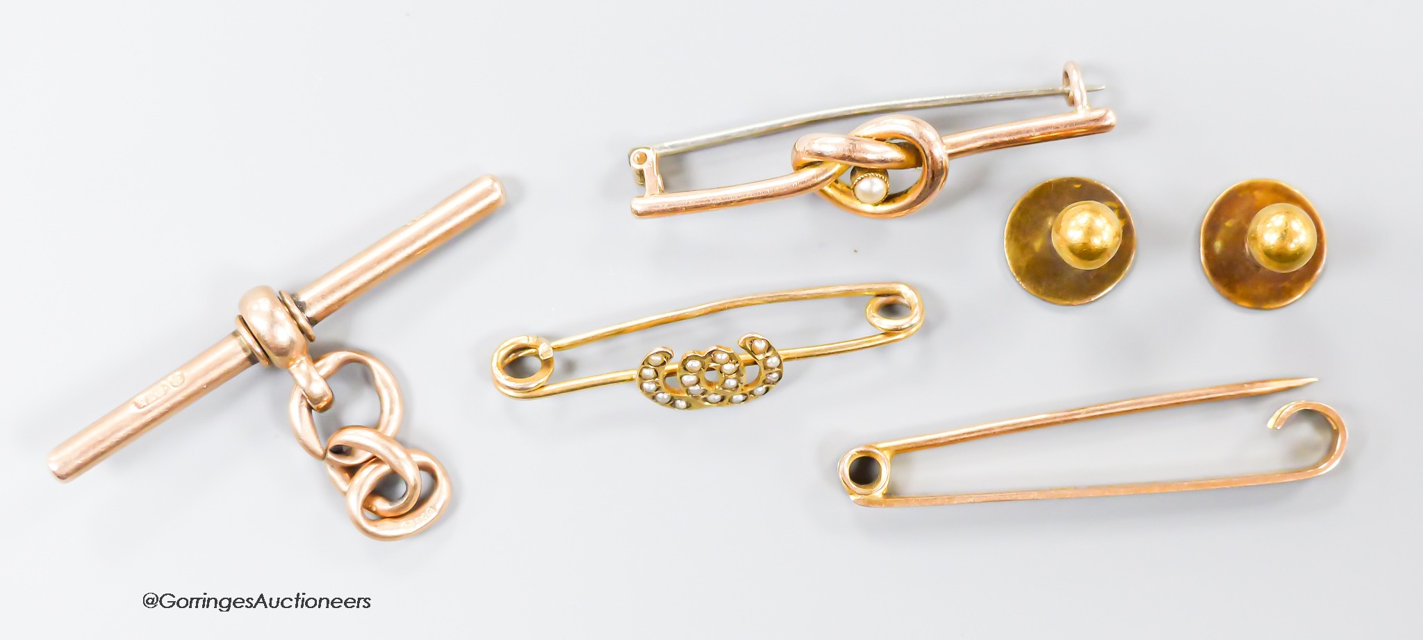 Two 9ct bar brooches and a9ct gold T-bar, gross 8.2 grams, a yellow metal and seed pearl bar brooch, gross 1.7 grams and two 15ct gold dress studs, 2.1 grams.